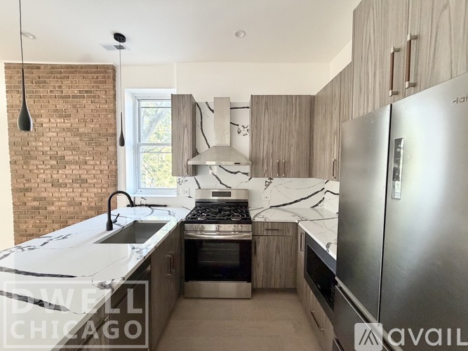 A kitchen with a brick wall and a stainless steel refrigerator.
