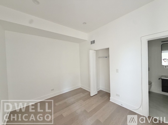 A spacious room with a doorway leading to another room.
