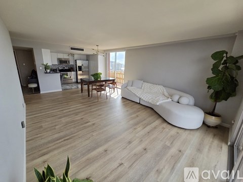 A living room with a white sofa and wooden flooring.