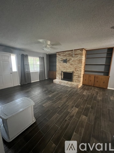 A room with a fireplace and wooden flooring.