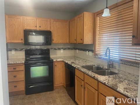A kitchen with wooden cabinets and a black oven.