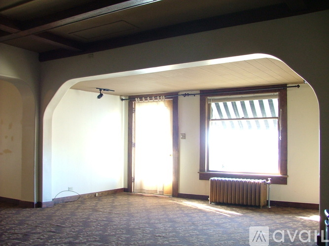 A room with a window and a radiator on the floor.