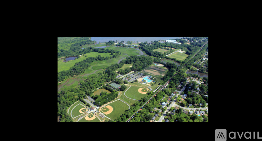 An aerial view of a baseball field surrounded by trees and a small lake.
