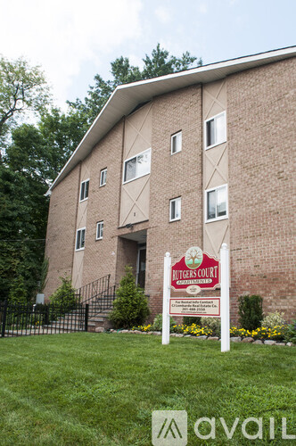 A brick building with a sign that says "Ritgers Court" in front of it.