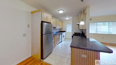 A kitchen with a refrigerator, sink, and cabinets.