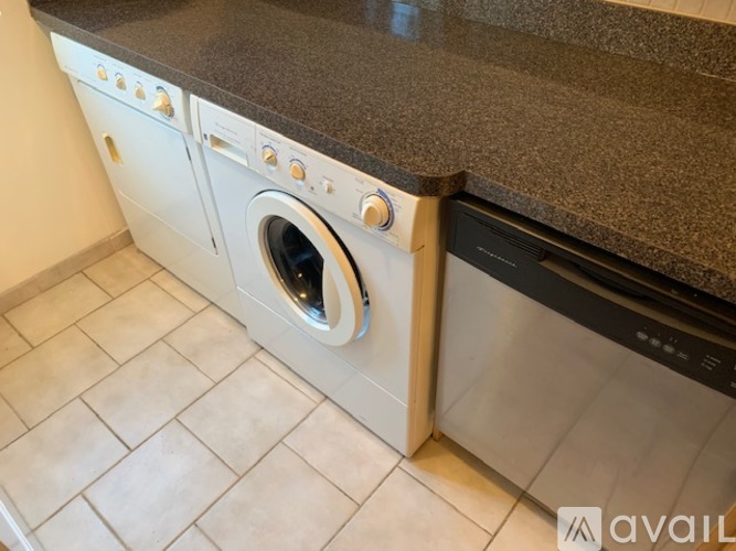 A modern kitchen with a washing machine built into the counter.