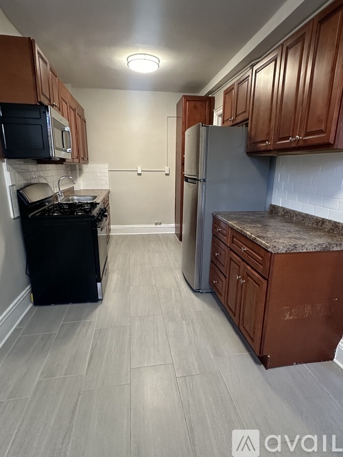 A kitchen with brown cabinets and a black stove top oven.