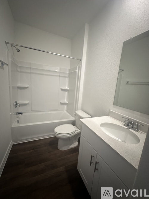 A white bathroom with a toilet, sink, and bathtub.