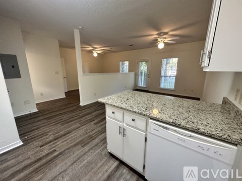 A kitchen with granite countertops and white cabinets.