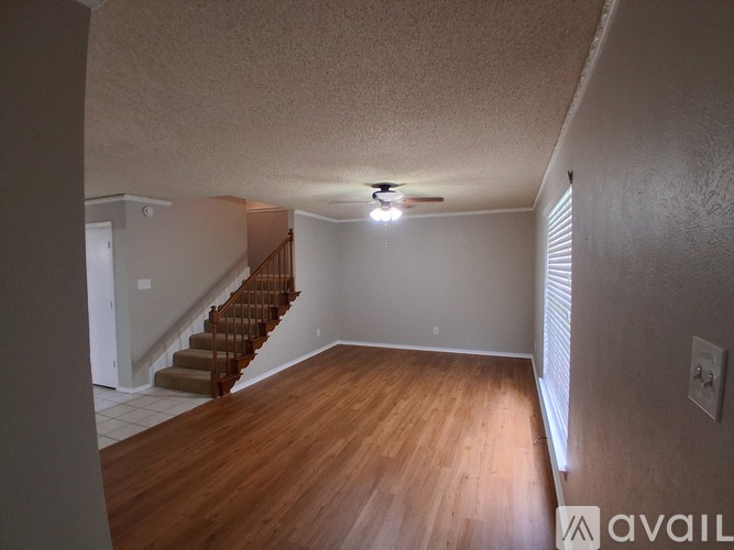 A room with wooden floors and a staircase.