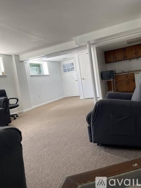 A living room with a black couch and a television.