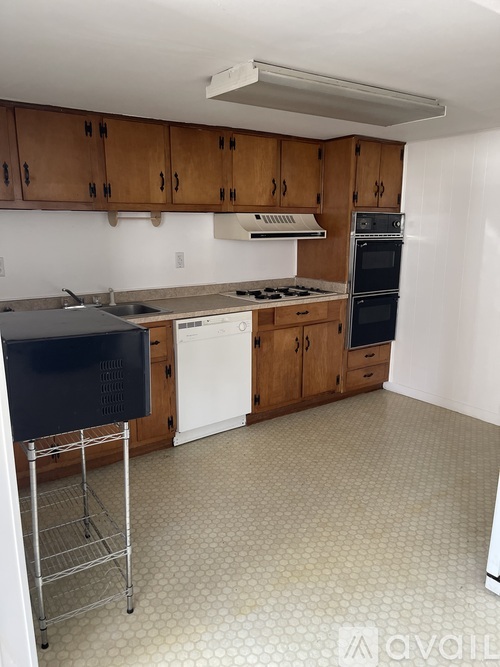 A kitchen with wooden cabinets and white appliances.