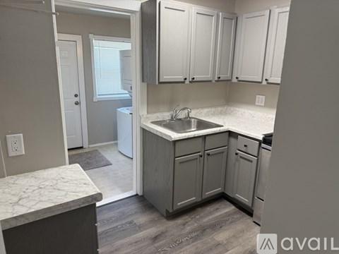 A kitchen with a white countertop and cabinets.