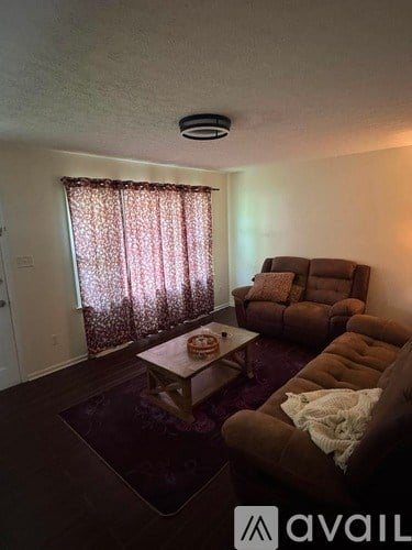 A living room with a brown couch and a coffee table.