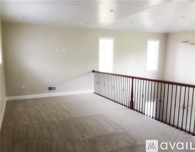 A spacious room with a balcony and hardwood flooring.