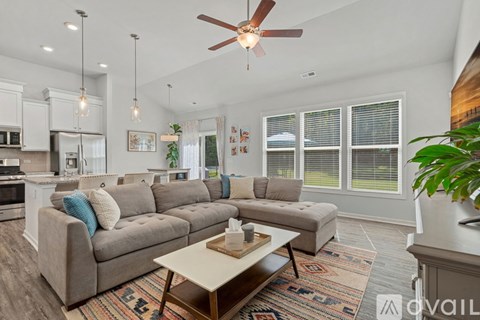 A living room with a grey couch and a wooden coffee table.