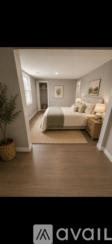 A bedroom with a bed, nightstand, and a plant.