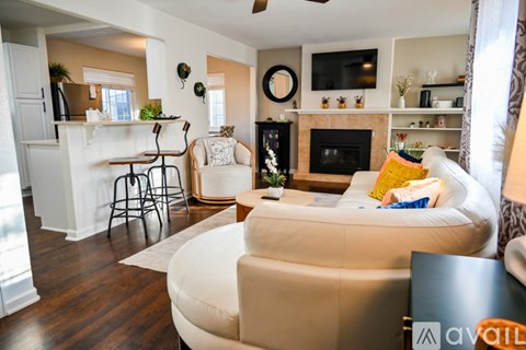 A living room with a white couch and a fireplace.