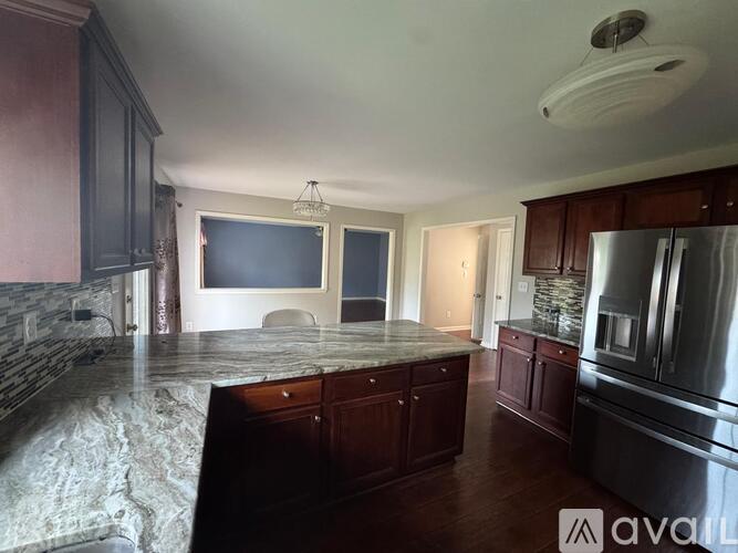 A kitchen with dark wood cabinets and a granite countertop.