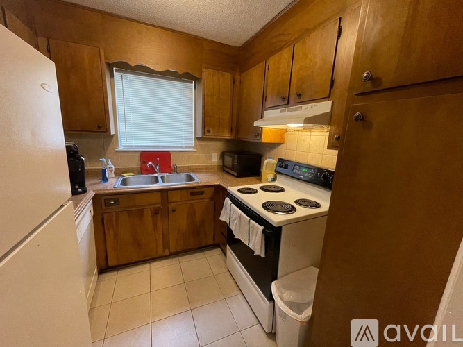 A kitchen with wooden cabinets and white appliances.