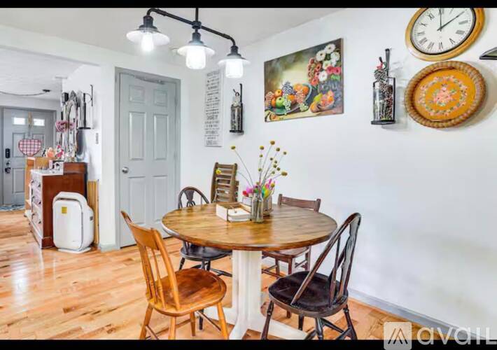 A dining room with a round table and chairs.