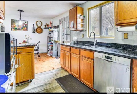 A kitchen with wooden cabinets and a black countertop.