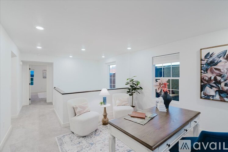 A modern living room with a white sofa, a wooden coffee table, and a painting on the wall.