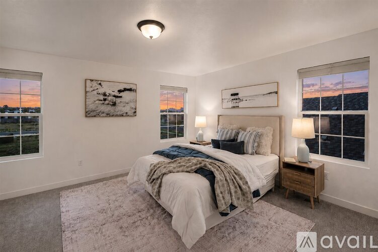A bedroom with a large bed and two windows overlooking a body of water.