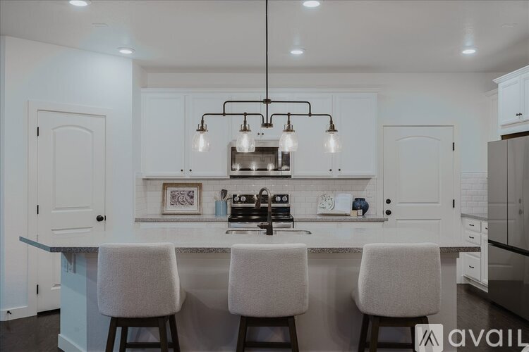 A modern kitchen with white cabinets and a central island.