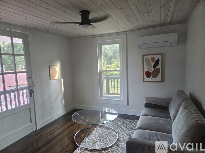 A living room with a grey couch and a glass coffee table.