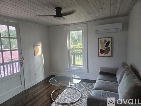 A living room with a grey couch and a glass coffee table.