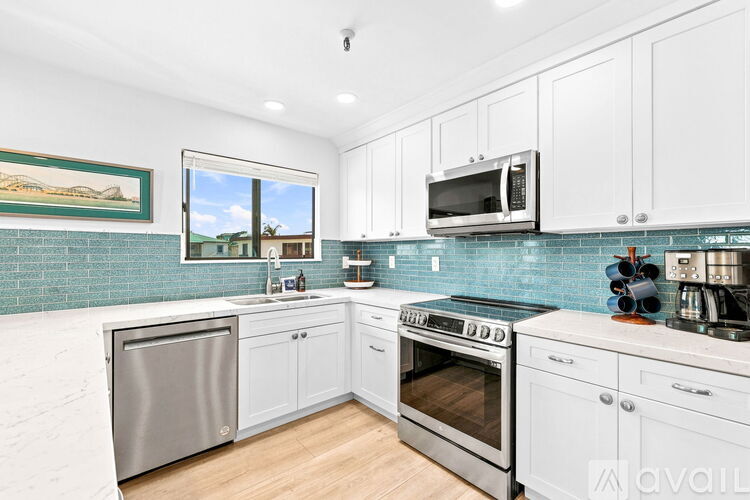 A kitchen with white cabinets and a stainless steel dishwasher.