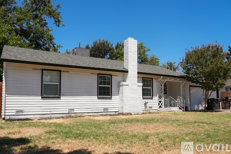 A white house with a chimney and a porch.