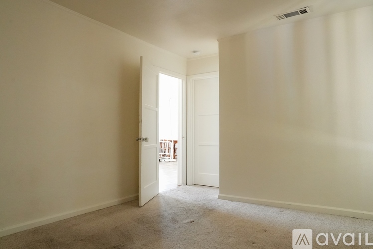 A room with a carpeted floor and a doorway leading to another room.
