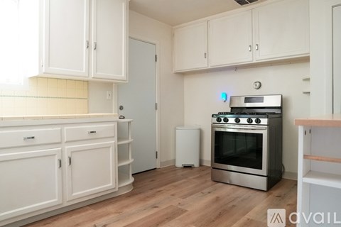 A kitchen with white cabinets and a stainless steel oven.