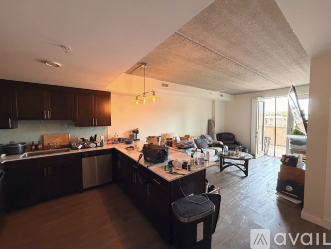 A kitchen with dark wood cabinets and a large island with a black chair.