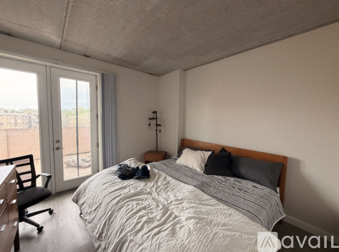 A bedroom with a large bed and a chair.