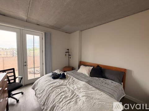 A bedroom with a large bed and a chair.