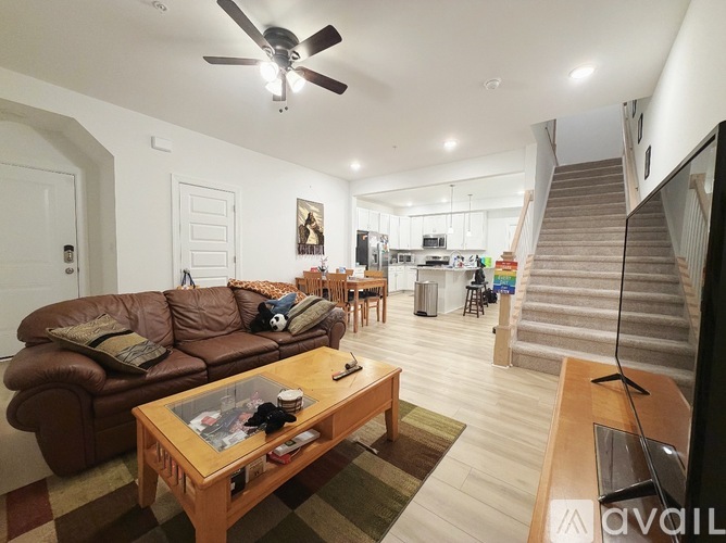 A living room with a brown leather couch and a wooden coffee table.