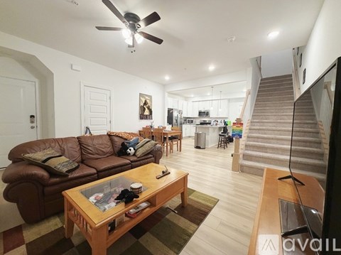 A living room with a brown leather couch and a wooden coffee table.