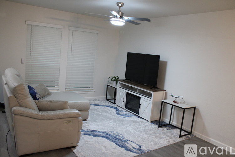 A living room with a television, a chair, and a small table.
