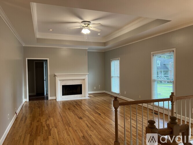 A living room with a fireplace and wood flooring.