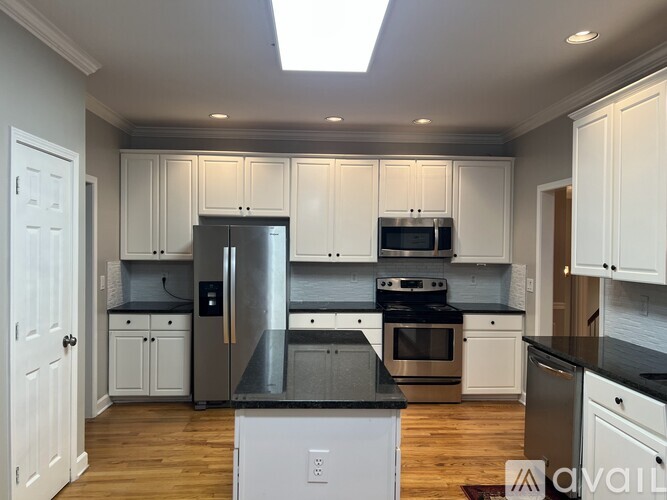 A kitchen with white cabinets and stainless steel appliances.