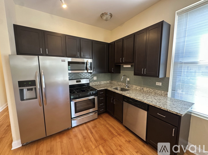 A kitchen with black cabinets and stainless steel appliances.