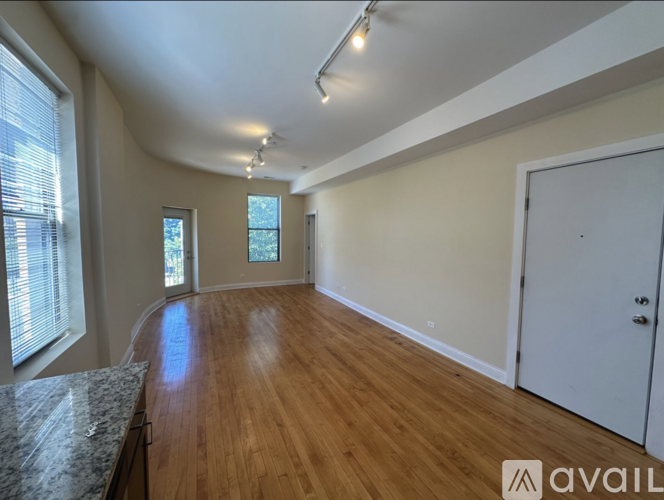 A spacious room with wooden floors and white walls.