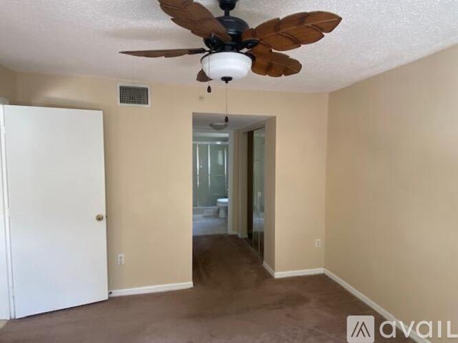 A room with a ceiling fan and a door.
