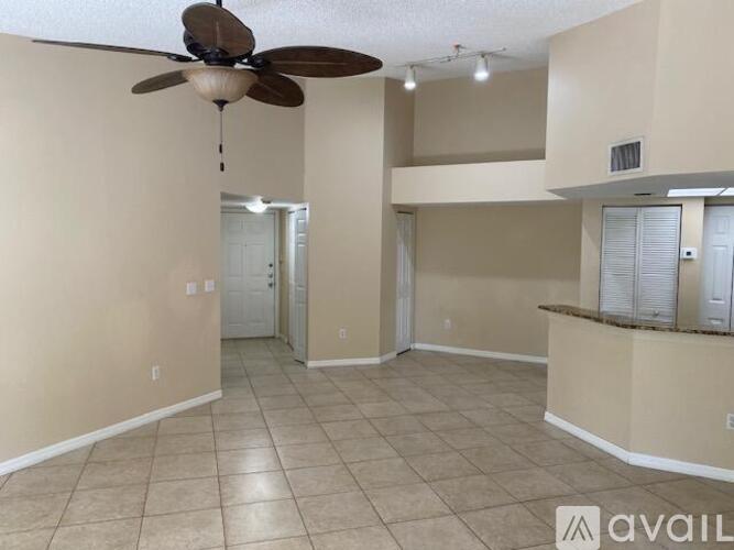 A spacious room with a ceiling fan and tiled flooring.