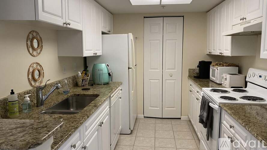 A kitchen with white cabinets and a granite countertop.