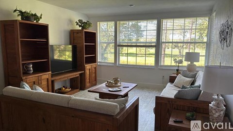 A living room with a couch, a coffee table, and a television.