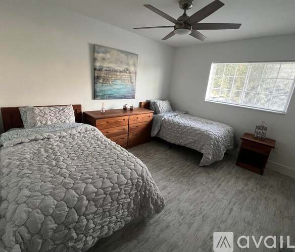 A bedroom with two beds and a ceiling fan.